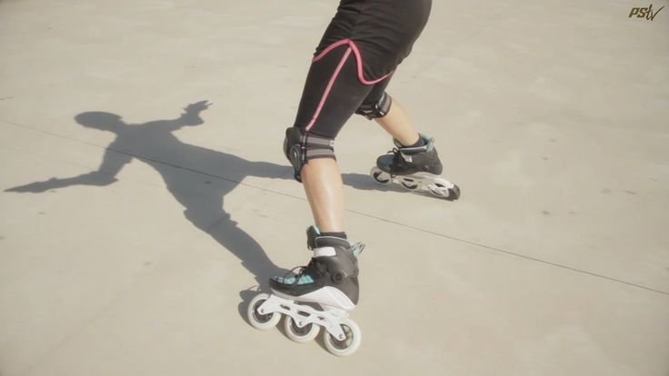A person performing a T-stop on inline skates, dragging one foot perpendicular to their direction of travel to slow down